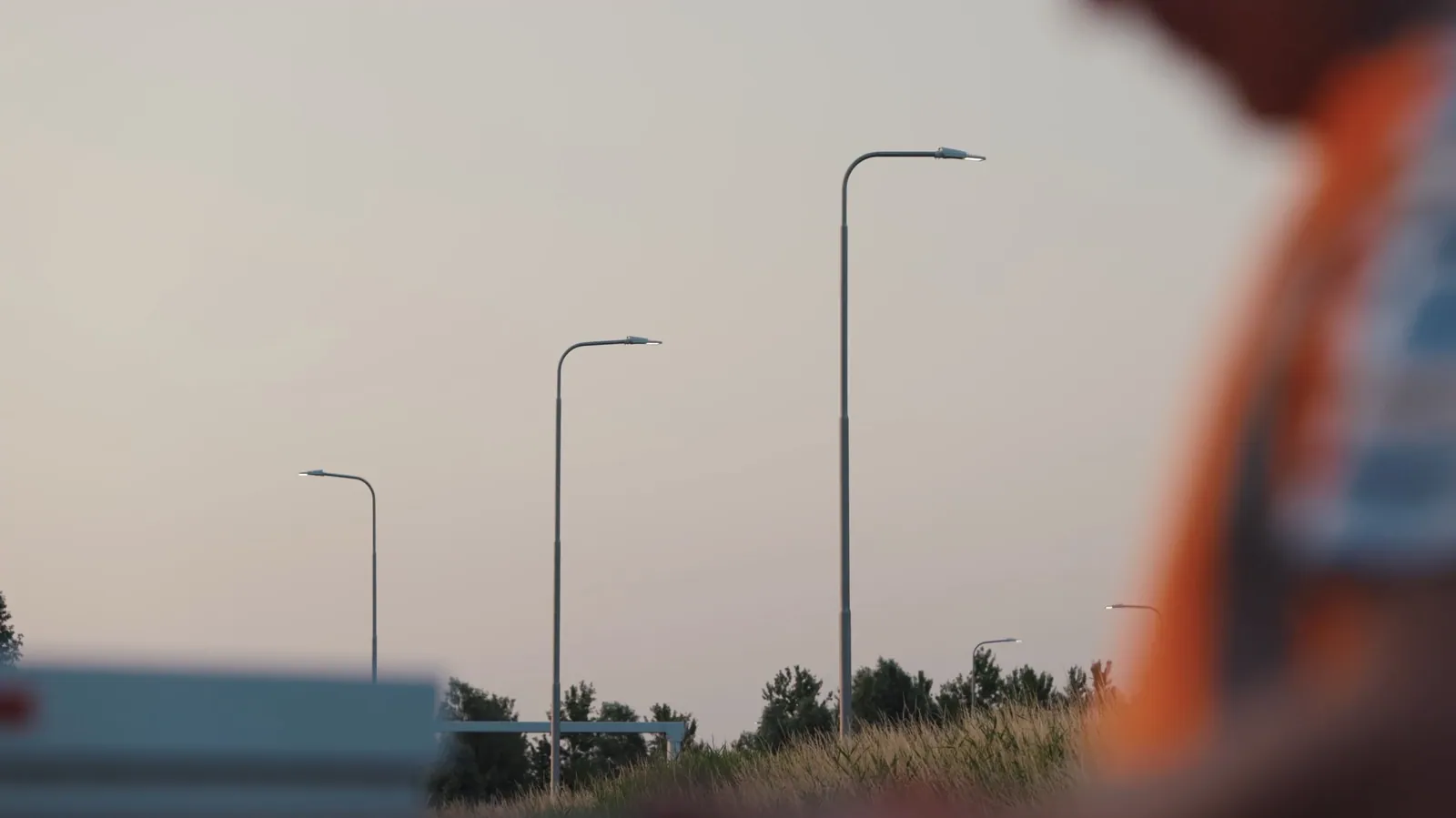 Lantaarnpalen langs een weg, met een monteur onscherp op de voorgrond