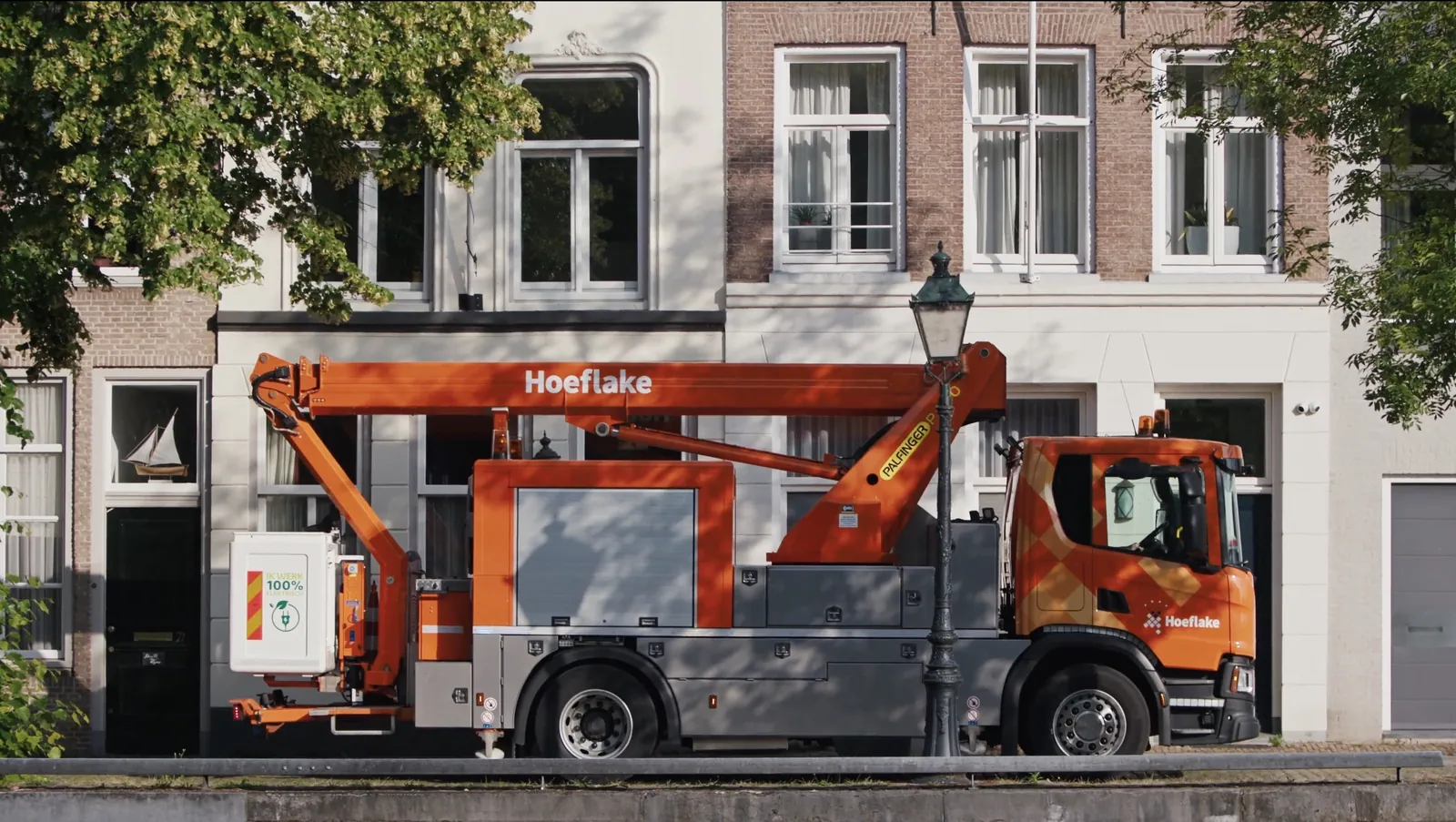 Hoeflake-hoogwerker naast een historische lantaarnpaal in een stadsstraat